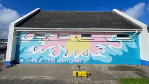 Cette peinture murale porte un message irlandais qui signifie "ensemble avec les vagues"